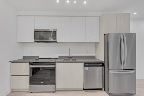 a modern kitchen with stainless steel appliances and white cabinets