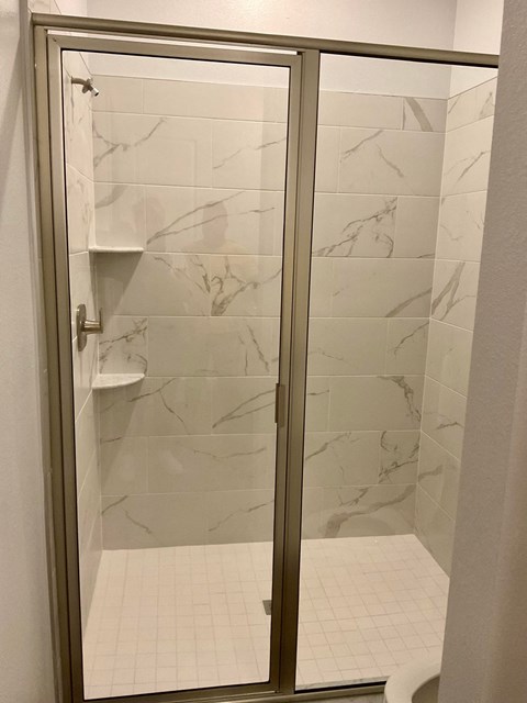 a bathroom with a shower with a glass door