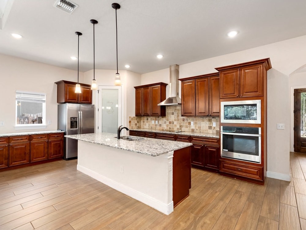 a large kitchen with a large island and wooden cabinets