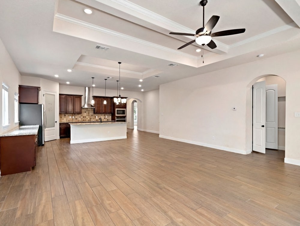 an open kitchen and living room with a ceiling fan