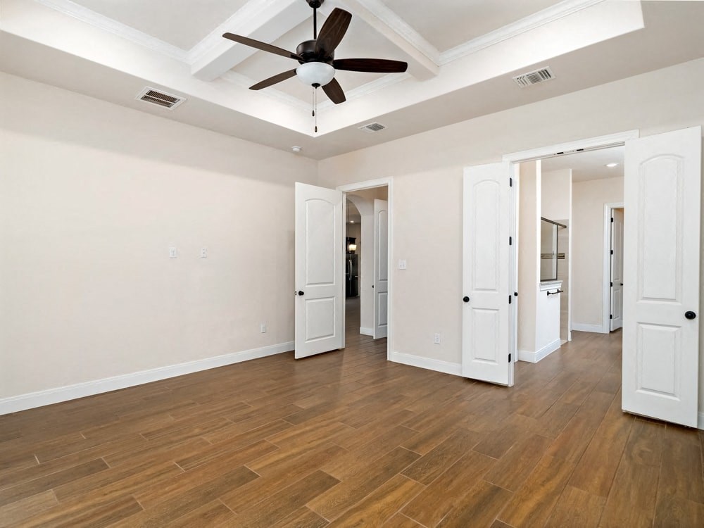 a living room with white walls and a ceiling fan