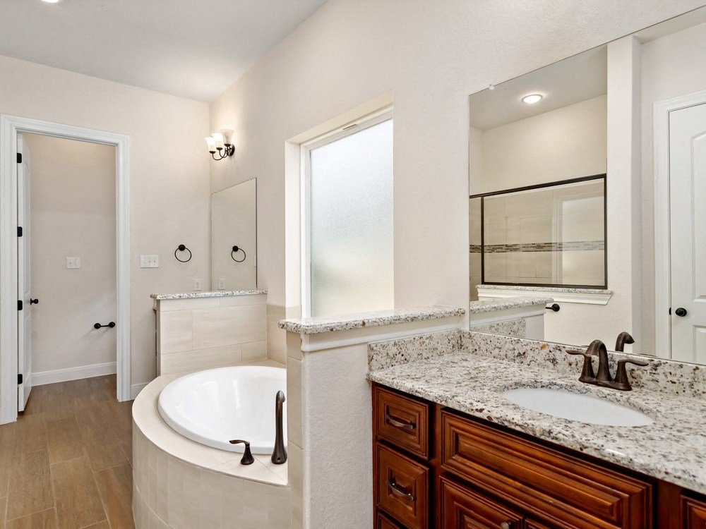 a bathroom with a tub and a sink and a mirror