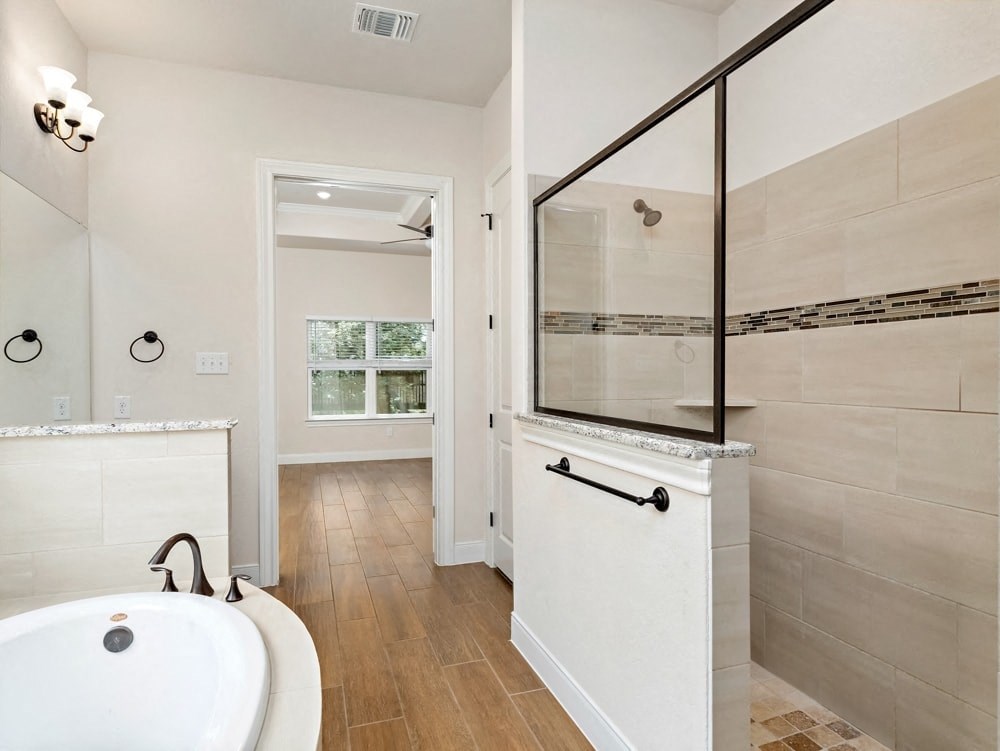 a bathroom with a tub and a shower and a sink