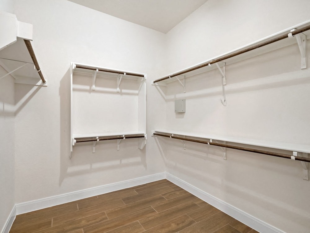 a empty room with white walls and shelves and a wood floor