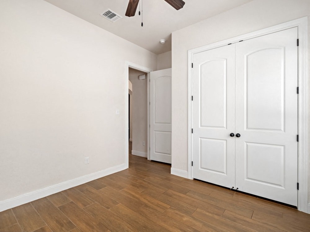 a bedroom with two closets and a door to a hallway