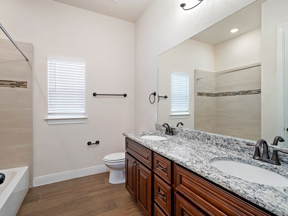 a bathroom with two sinks and a shower and a toilet