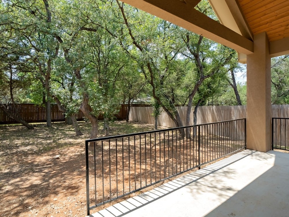 the deck of a house with a fence and trees