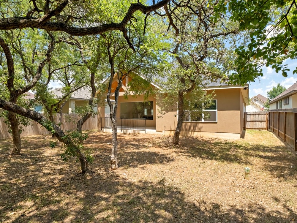 a house with a yard and trees in front of it