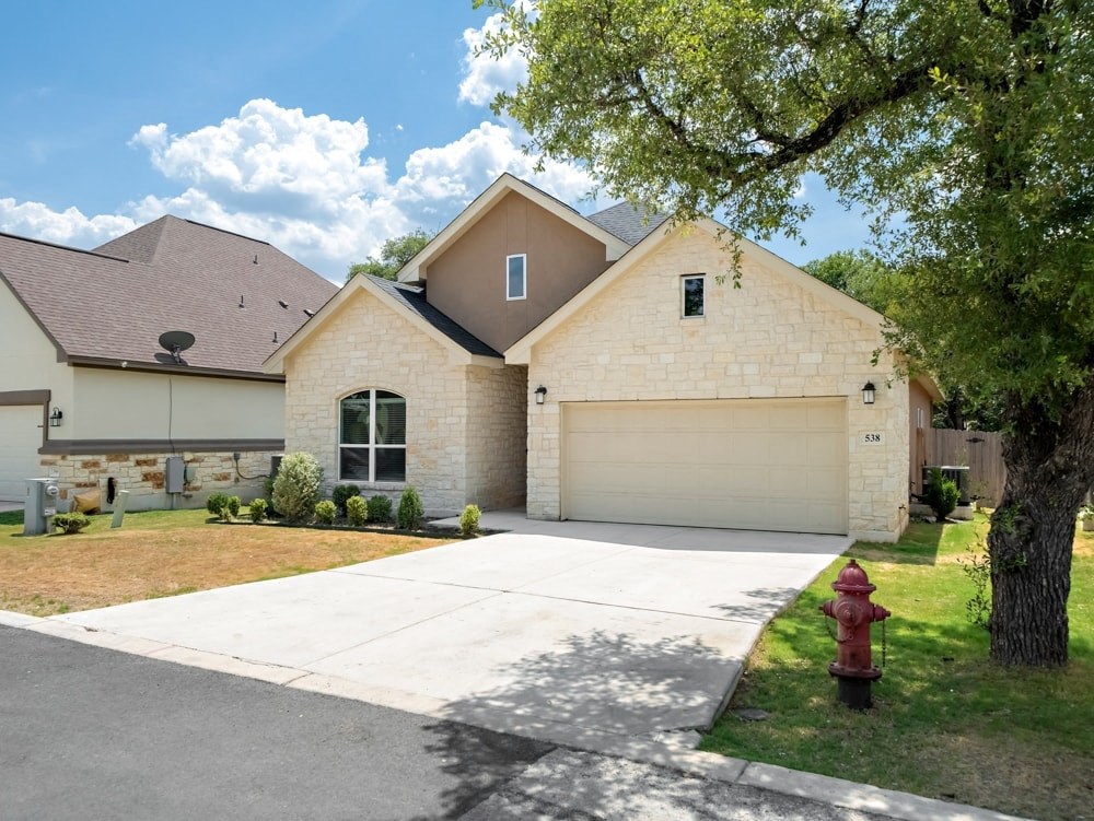 a house with a driveway and a fire hydrant in front of it