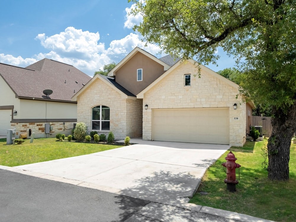 a house with a driveway and a fire hydrant in front of it
