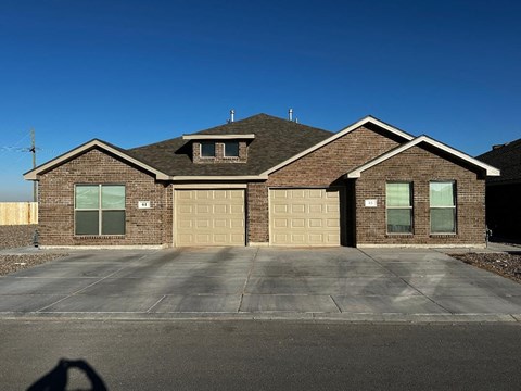 a brick house with a garage and a blue sky