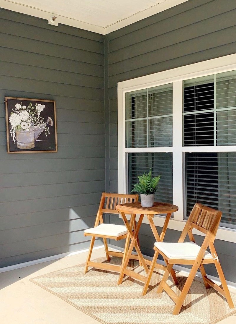 a patio with a wooden table and chairs on a porch