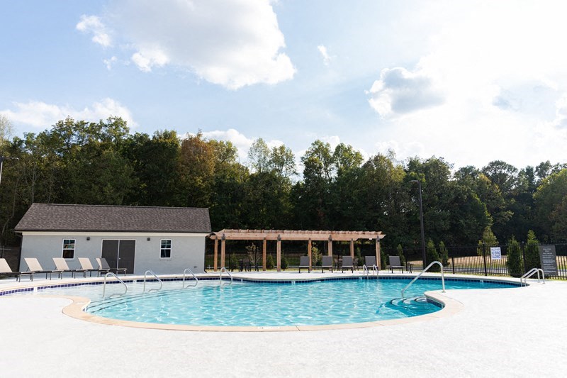 a large pool with chairs around it in front of a building