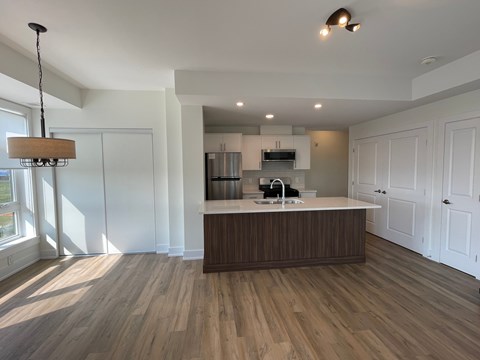 A kitchen with a wooden floor and white walls.