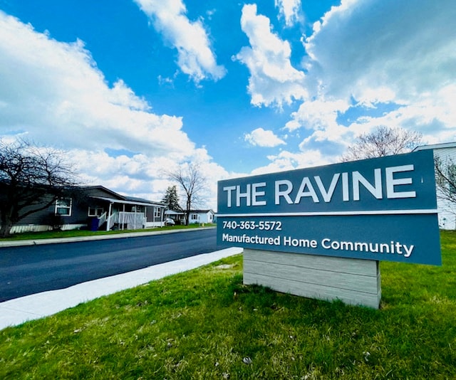 the ravine real estate sign in front of a house