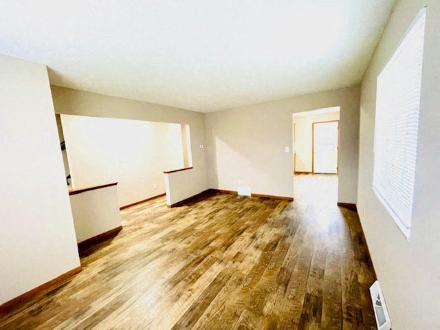 an empty living room with wood floors and white walls
