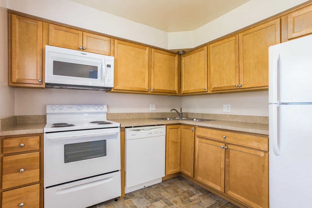 a kitchen with white appliances and wooden cabinets