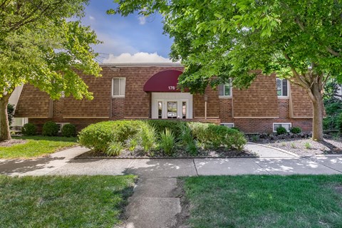 A red brick house with a white door and windows.