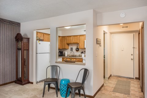 a kitchen and dining room with two chairs and a refrigerator