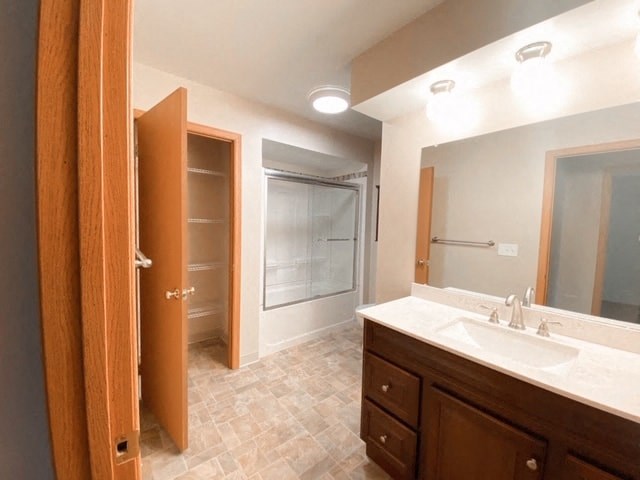 a bathroom with a sink and a shower and a mirror