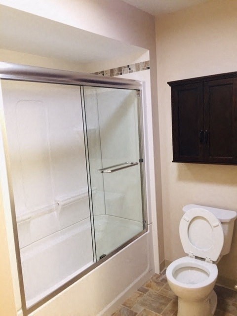 a bathroom with a toilet and a shower