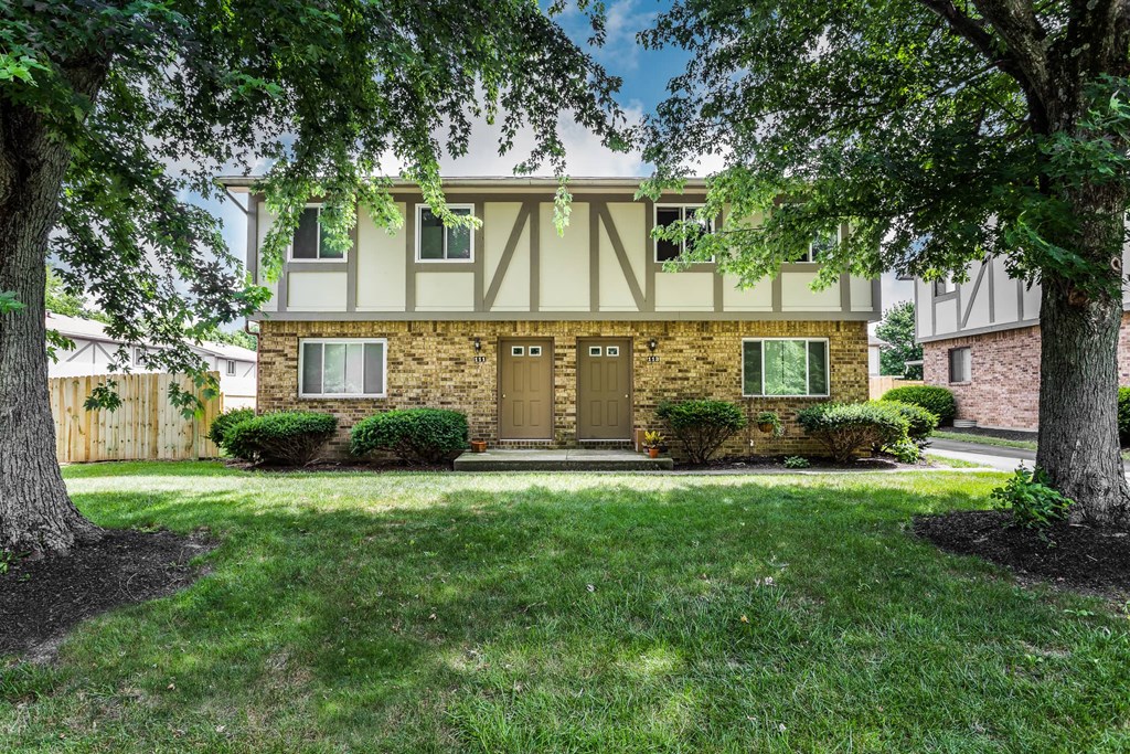 the front of a house with trees in front of it