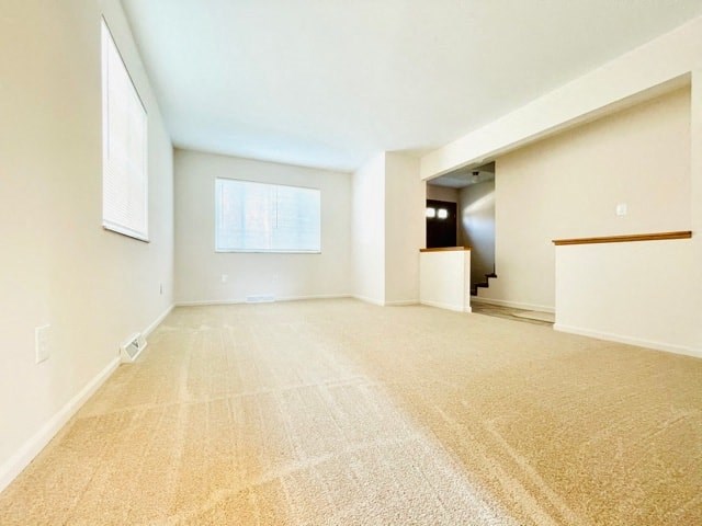 an empty living room with white walls and a carpeted floor