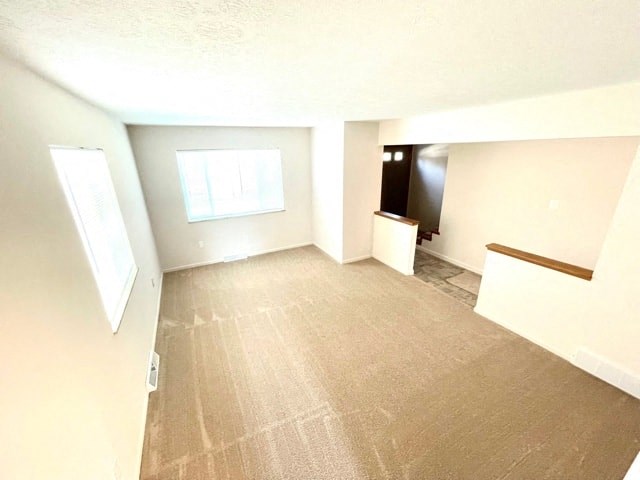an empty room with a carpeted floor and a window