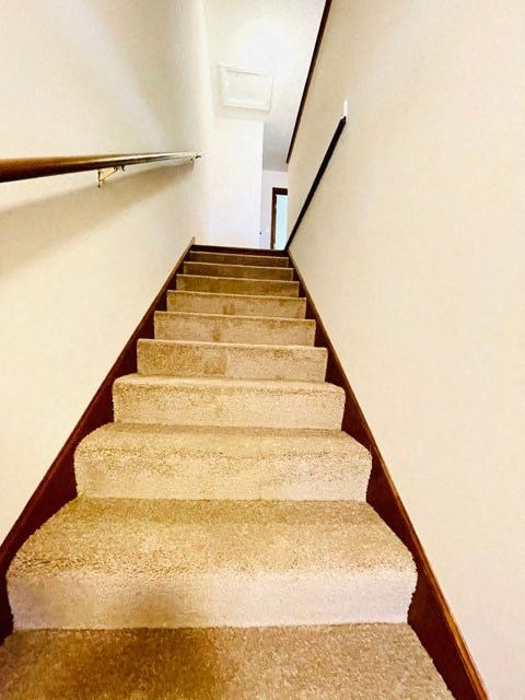 a set of stairs with a white wall and a railing