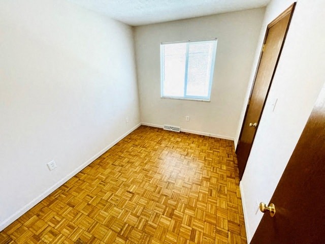 an empty room with wood flooring and a window