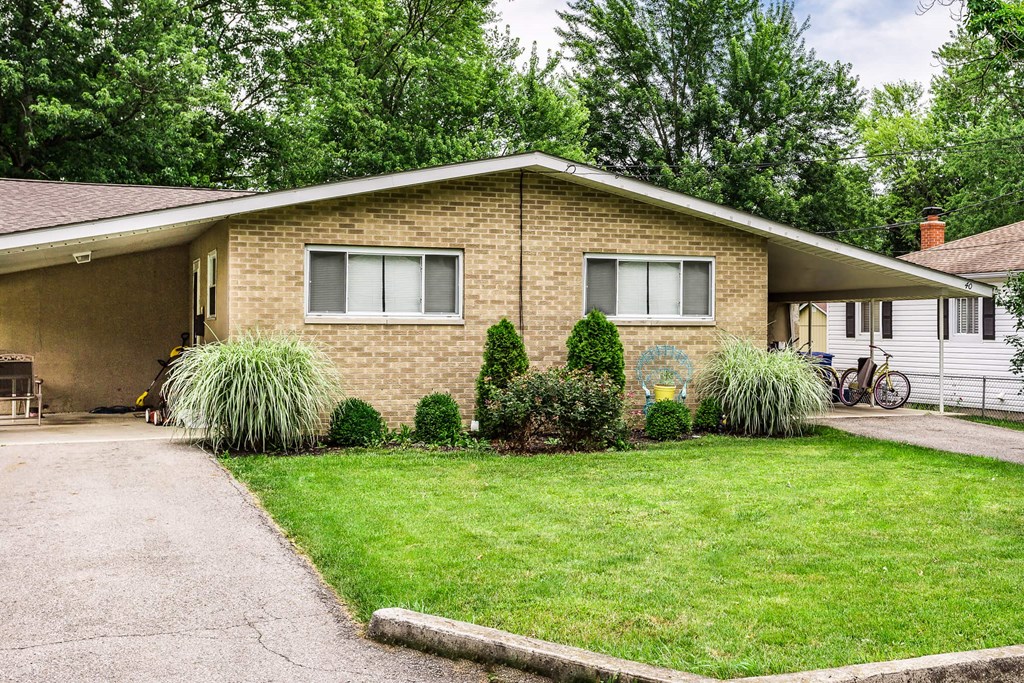 a house with a lawn and a bike parked in front of it