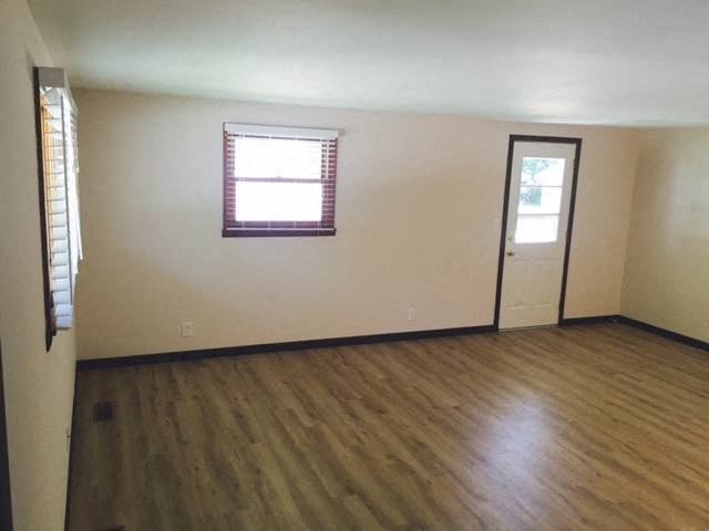 a living room with a wooden floor and a window