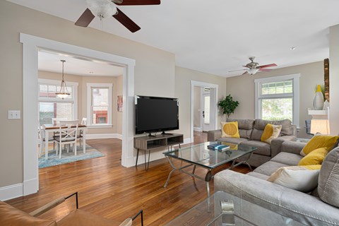 A living room with a grey couch and a glass coffee table.