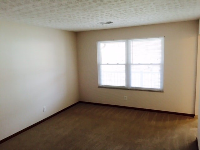 an empty room with a window and a wooden floor