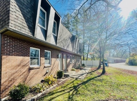 a brick house with a sidewalk in front of it