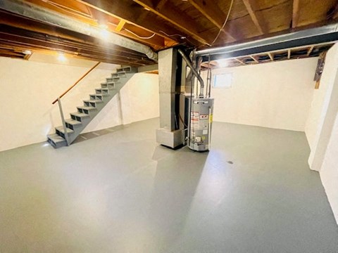 an empty garage with a staircase in the background