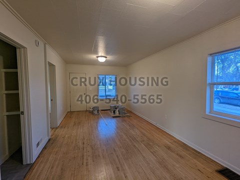 a living room with a hard wood floor and a window
