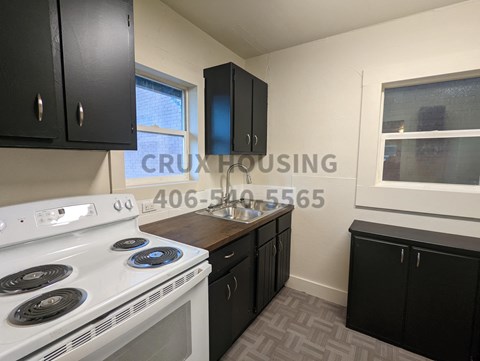 a small kitchen with a white stove and black cabinets