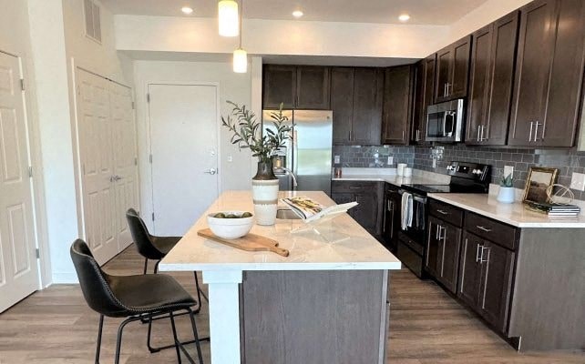 a kitchen with a white island and black cabinets