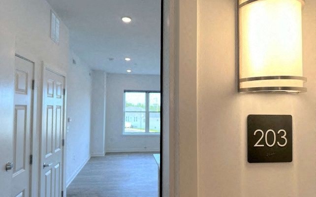 a hallway with a clock on the wall next to a door