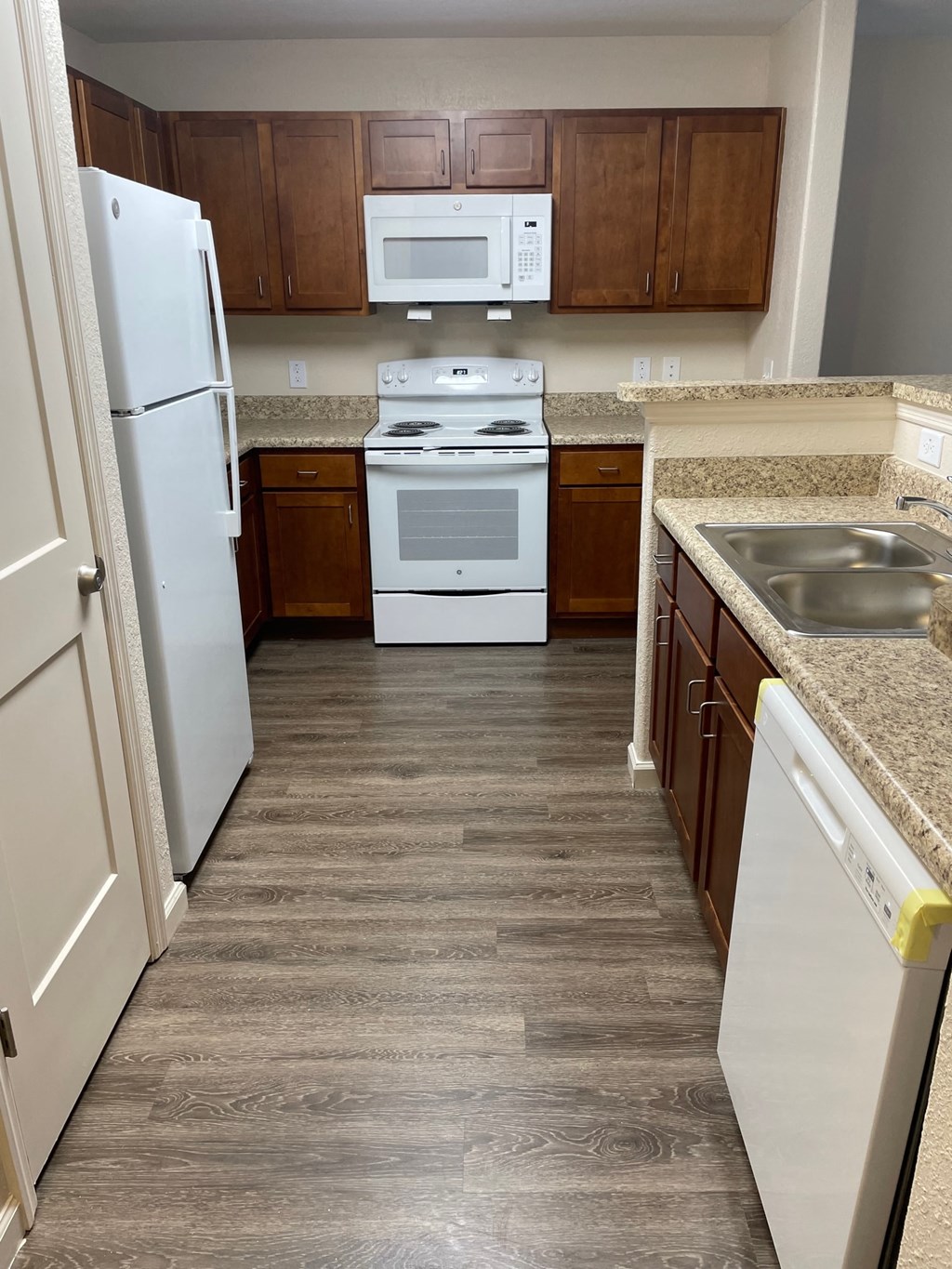 a kitchen with white appliances and wooden cabinets