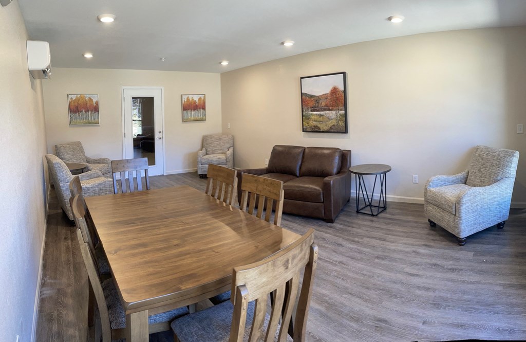 a living room and dining room with a wooden table and chairs