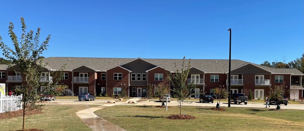 an apartment building with a yard in front of it