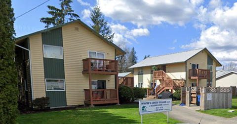 A sign in front of a building that says Winter Creek Village.