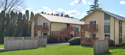 A large house with a porch and a deck.