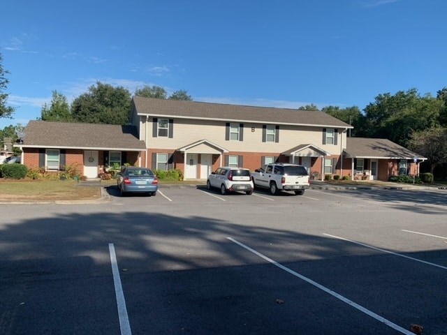 a parking lot with cars in front of a house