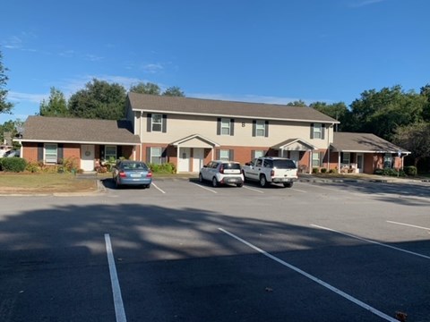 a parking lot with cars in front of a house