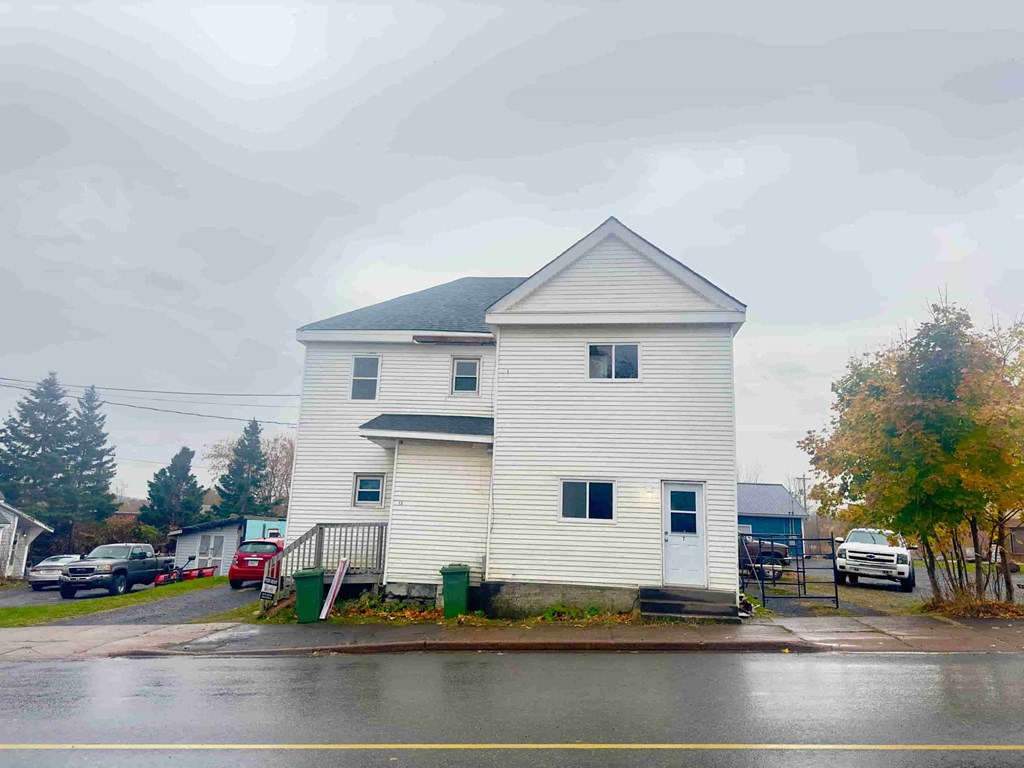 a white house on the corner of a rainy street