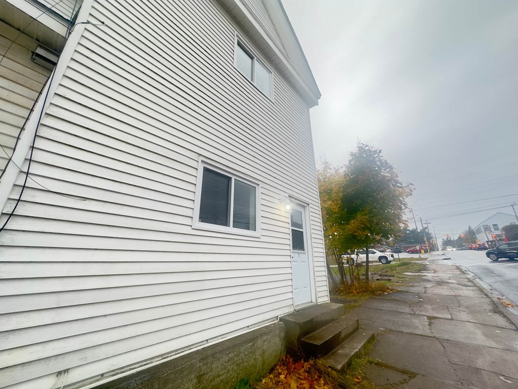 the side of a white house on a city street