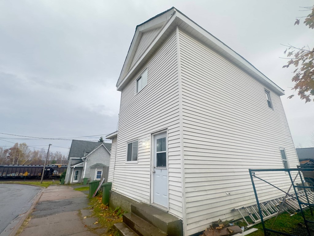 the side of a house with white siding and a blue door